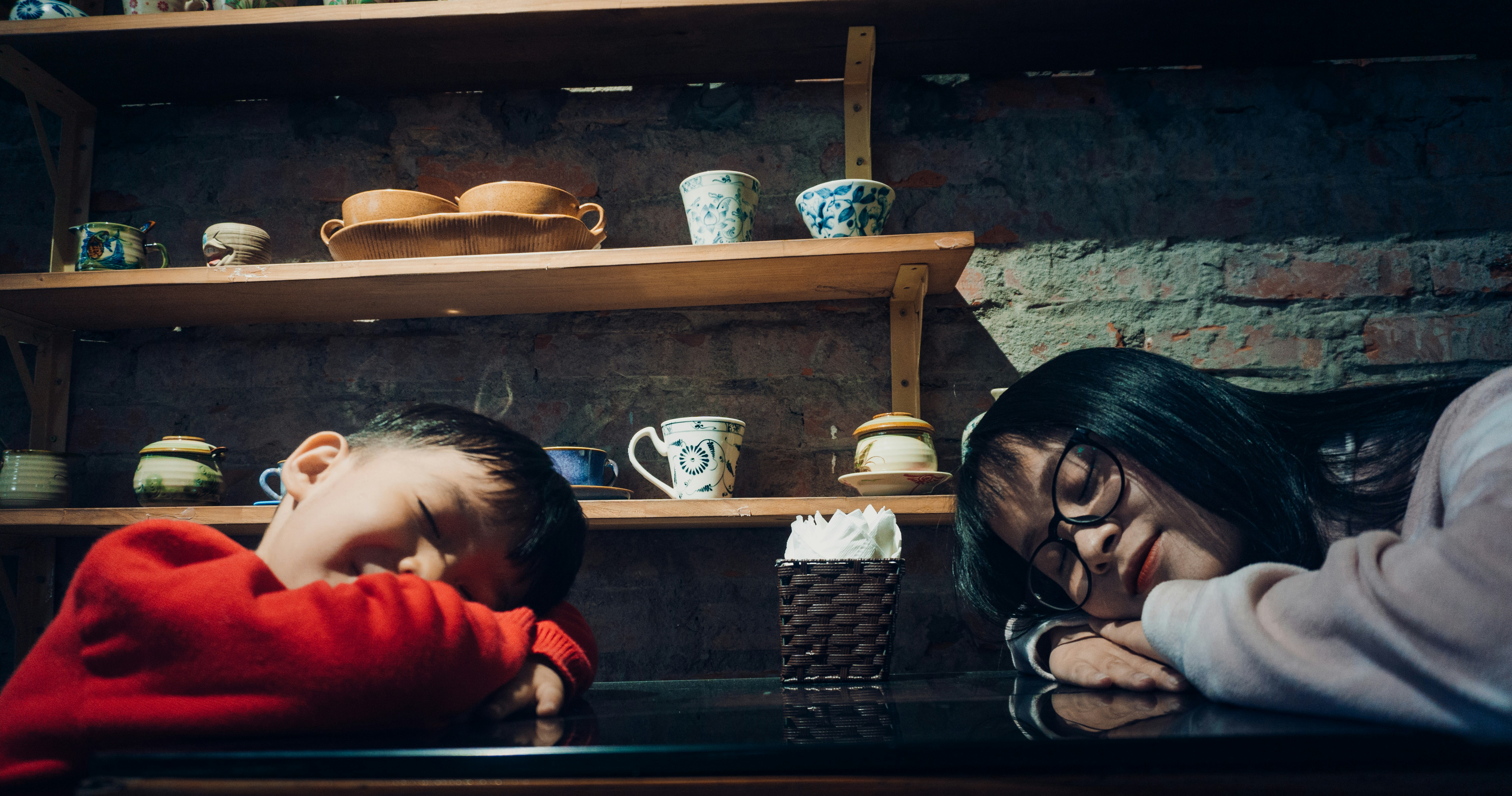 赤い長袖シャツで赤ん坊を運ぶ赤い長袖シャツの女性