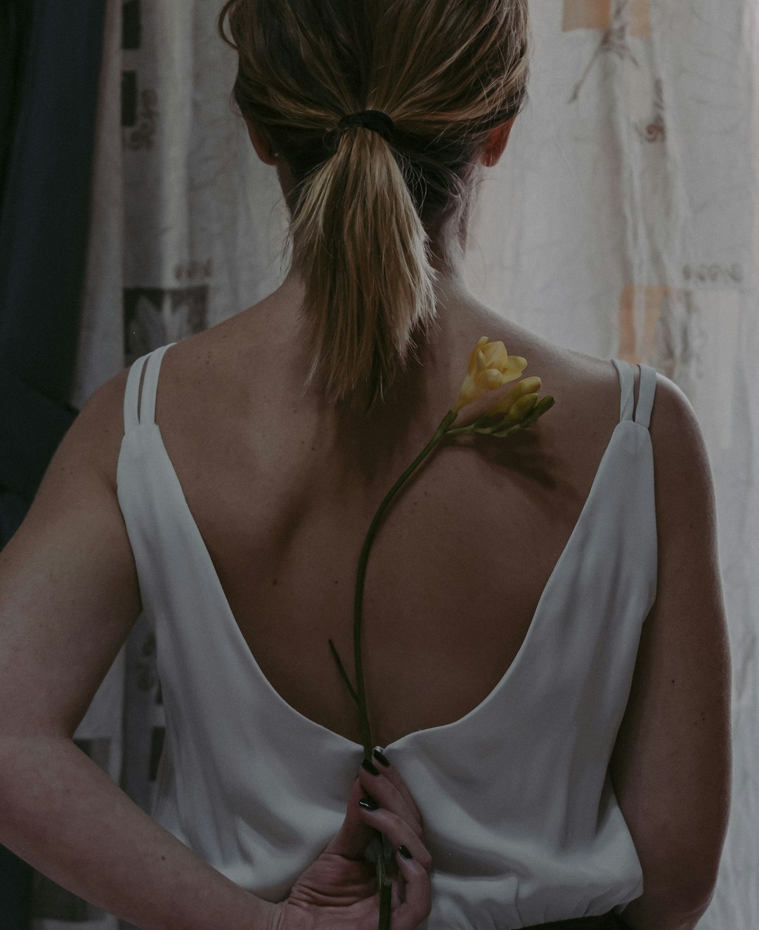 woman in white tank top with yellow flower on head
