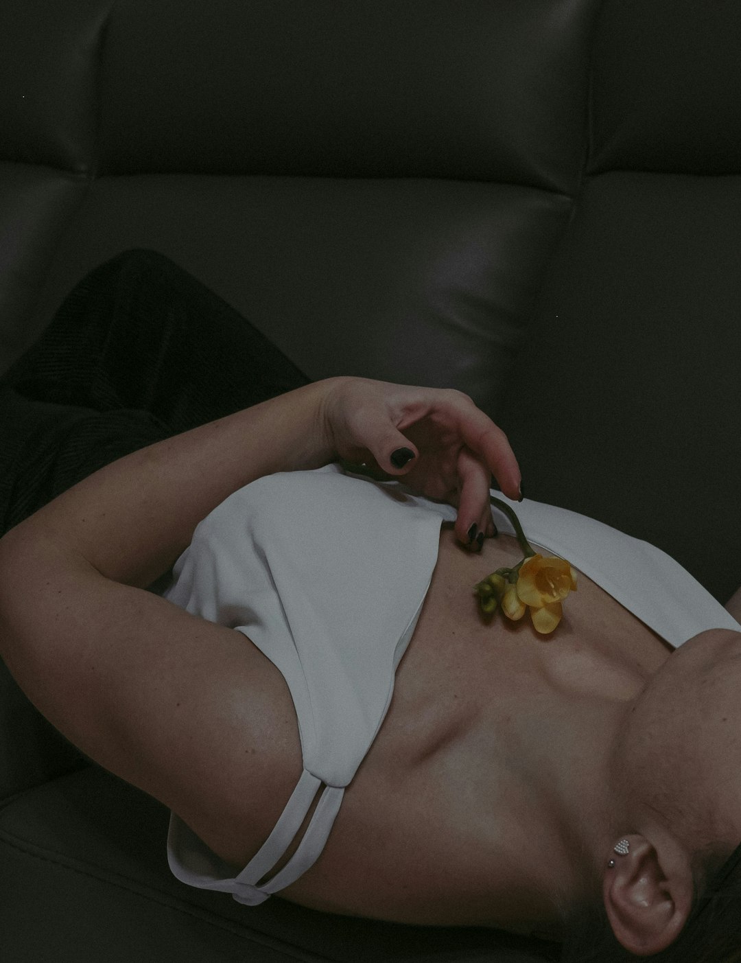 woman in white tank top holding yellow round fruit