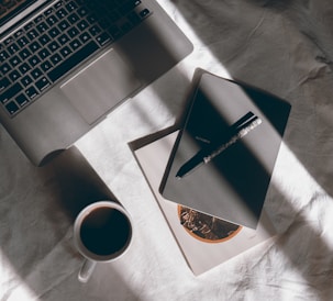 white ceramic mug beside macbook pro