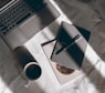 white ceramic mug beside macbook pro