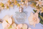 Soft pastel-colored car perfume bottle surrounded by delicate flowers