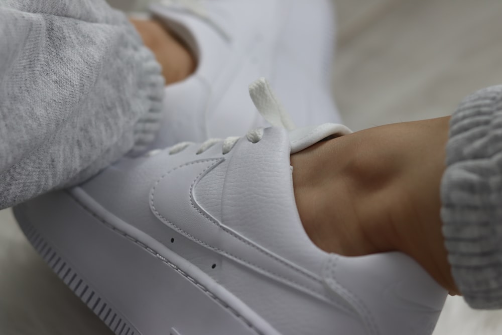 person wearing white nike athletic shoes