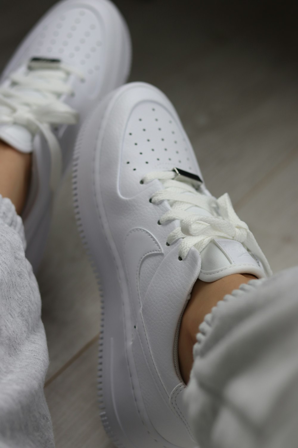 person wearing white nike air force 1 low