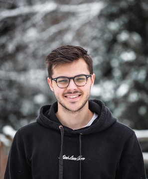 man in black hoodie wearing black framed eyeglasses