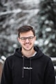 man in black hoodie wearing black framed eyeglasses