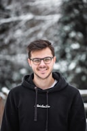 man in black hoodie wearing black framed eyeglasses