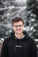 man in black hoodie wearing black framed eyeglasses
