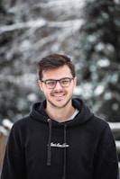 man in black hoodie wearing black framed eyeglasses