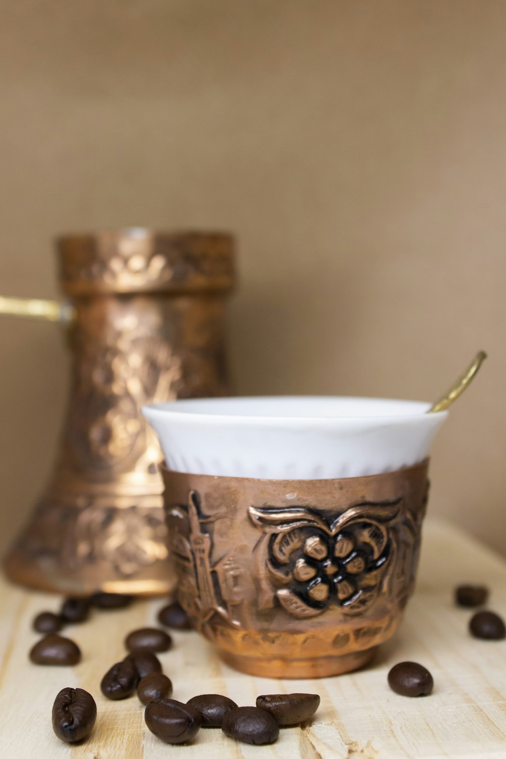white and gold ceramic cup on white table