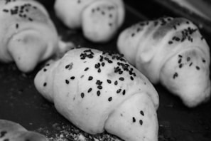 Freshly baked crescent rolls with a golden crust, steaming gently on a linen cloth beside a bowl of homemade soup
