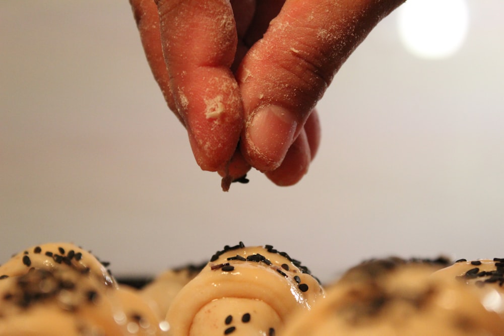 person holding brown and white doughnut