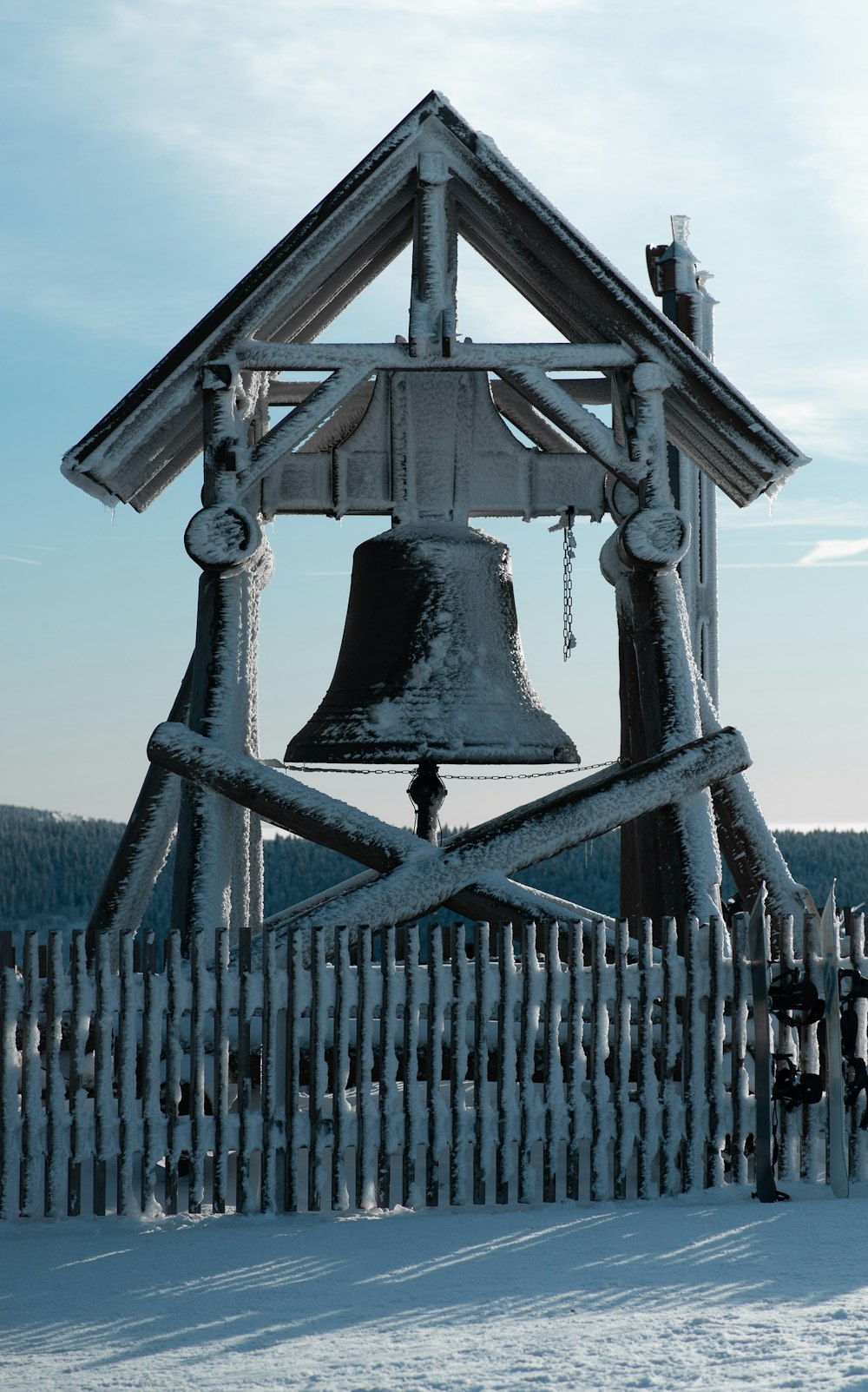 black bell on black wooden fence