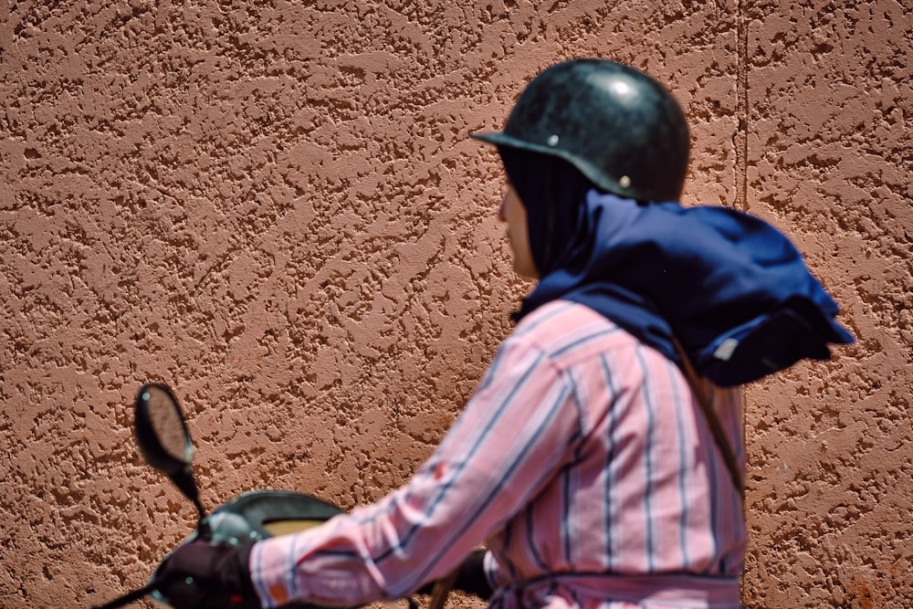 Hombre en chaqueta negra y azul y casco negro montando en motocicleta