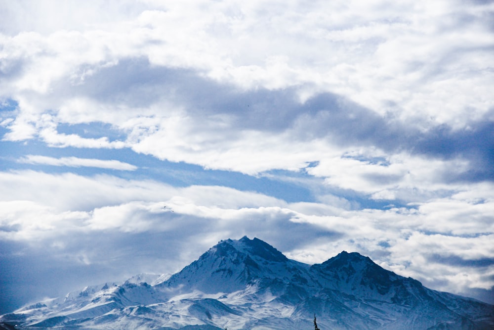 Schneebedeckter Berg tagsüber unter bewölktem Himmel