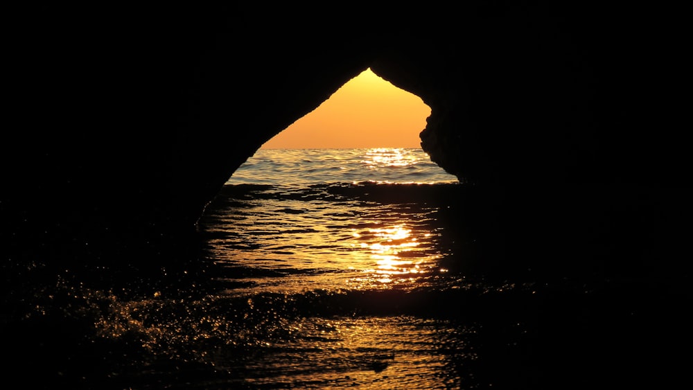 silhouette of cave during sunset