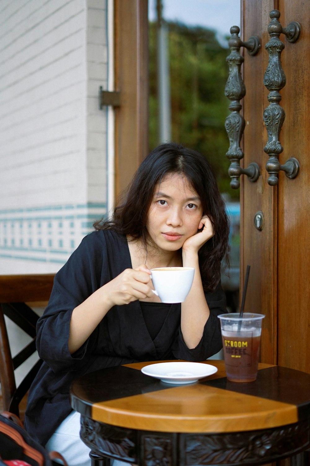 woman in black shirt holding white ceramic mug
