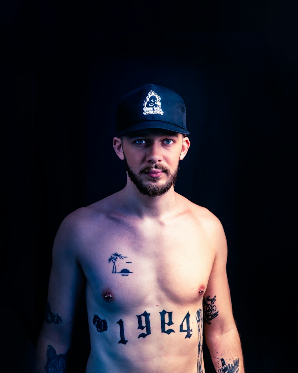 topless man wearing blue and black fitted cap