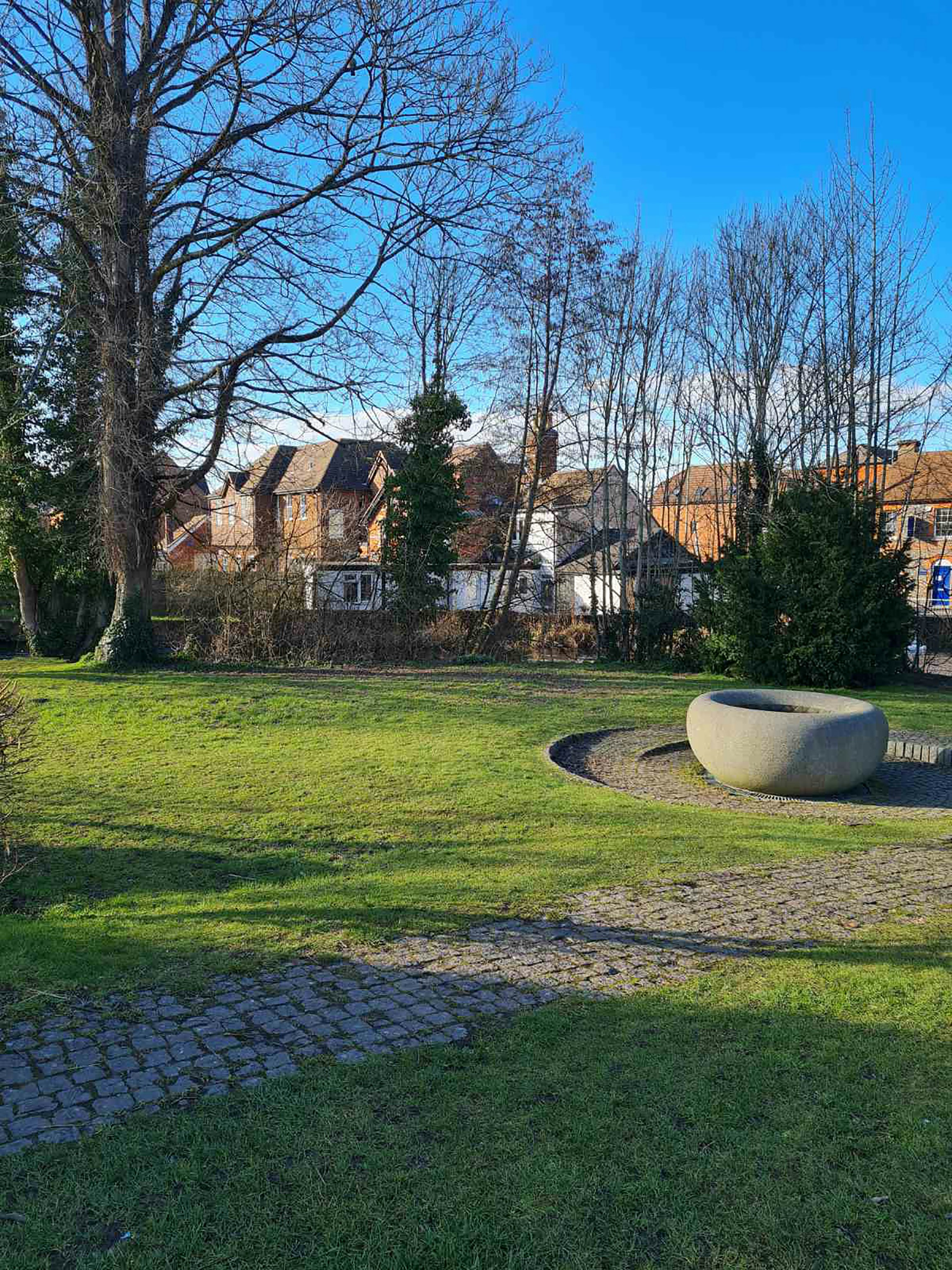 brown concrete building near bare trees under blue sky during daytime