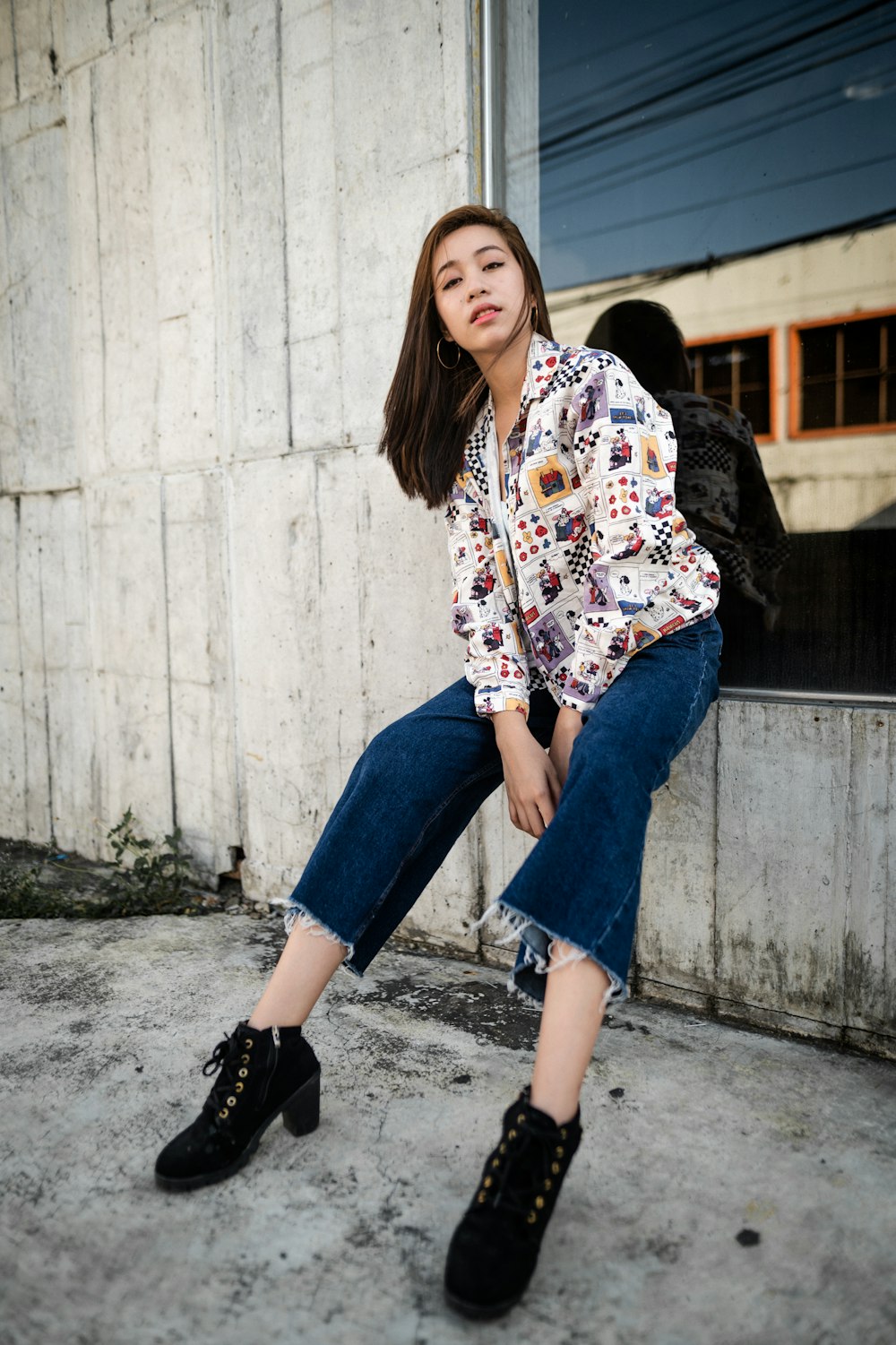 woman in white red and blue floral long sleeve shirt and blue denim jeans sitting on on on with on