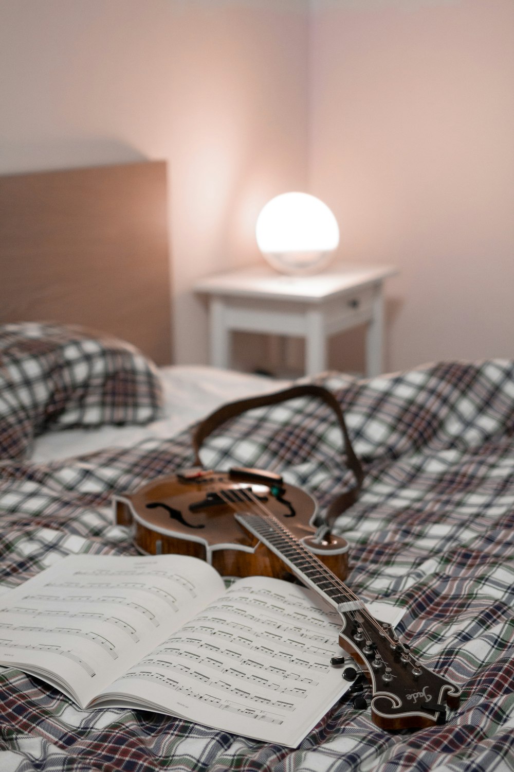 brown and white electric guitar on bed