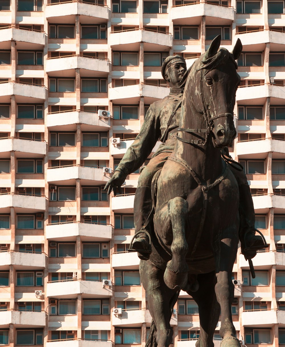 Statue de cheval noir près du bâtiment blanc pendant la journée