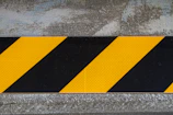 A vibrant yellow caution sign set against a gradient background of green to red zones