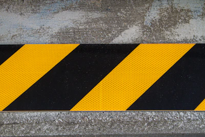 A vibrant yellow caution sign set against a gradient background of green to red zones