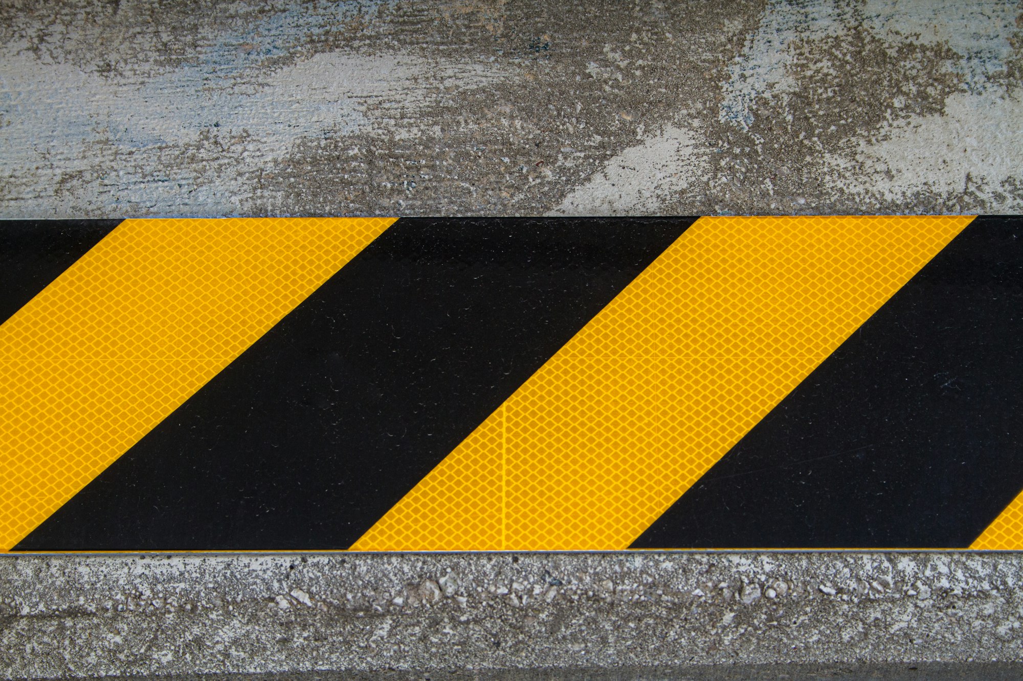 Black and yellow caution indicator on concrete