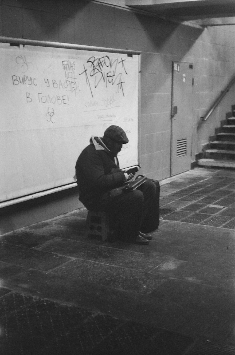 man in black jacket sitting on bench