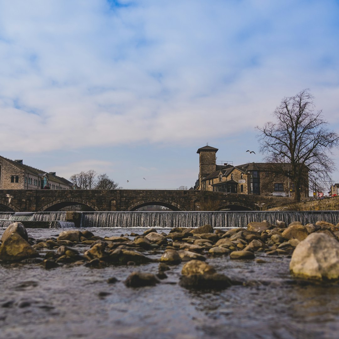 gray concrete bridge over river under blue sky during daytime