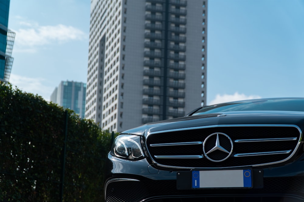 black mercedes benz car on road near high rise buildings during daytime
