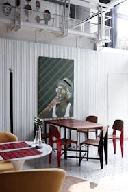 A dining space blending rustic wood, metallic accents, and colorful ceramics for a lively atmosphere.