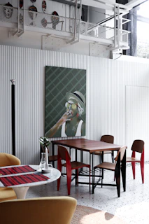 A dining space blending rustic wood, metallic accents, and colorful ceramics for a lively atmosphere.