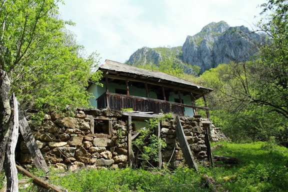 A rustic wooden farmhouse nestled in the lush Ybyturuzu mountain range at sunset.