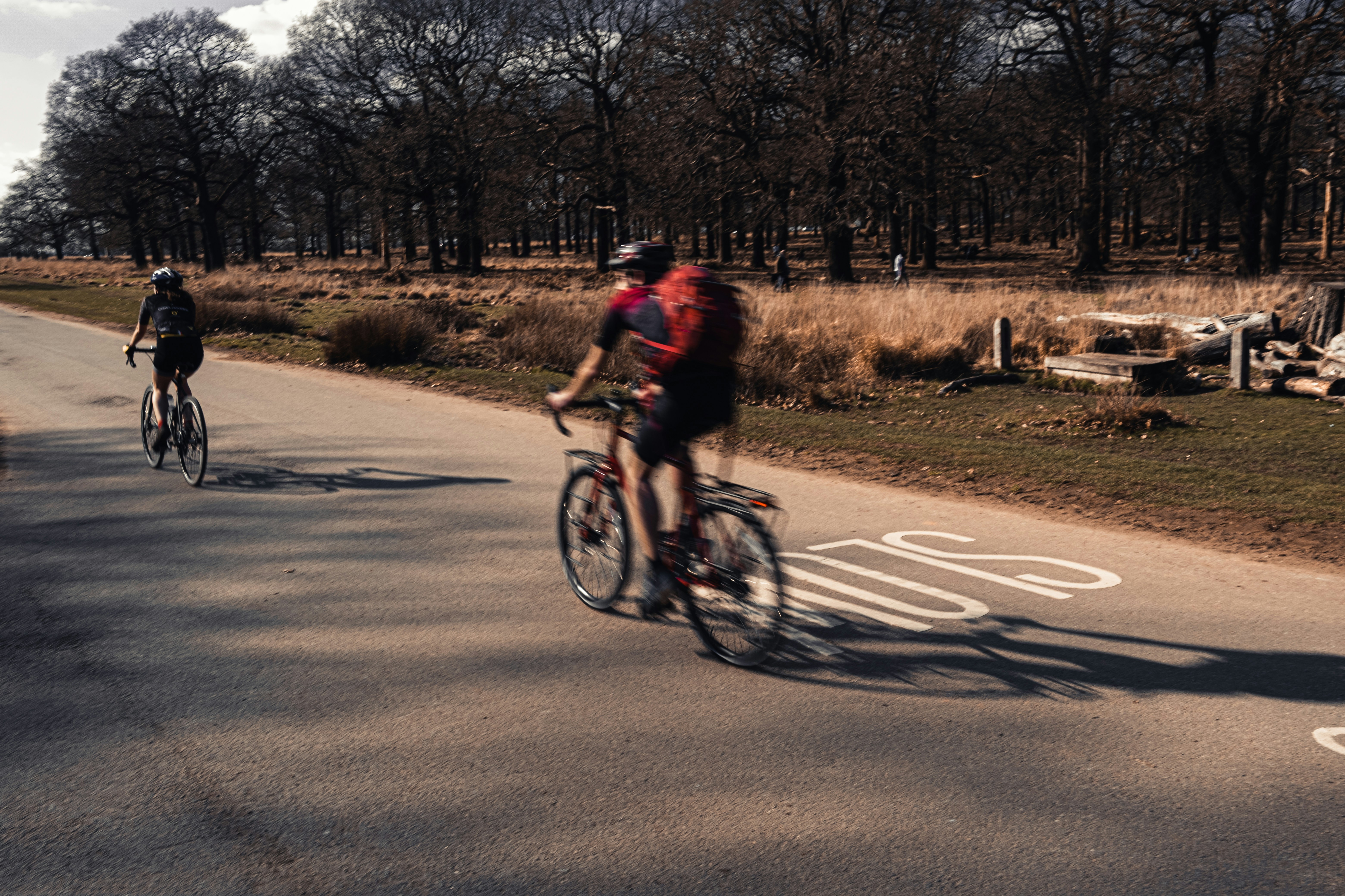 man in red shirt riding bicycle on road during daytime