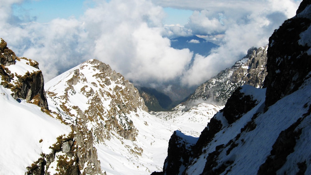 snow covered mountain under cloudy sky during daytime