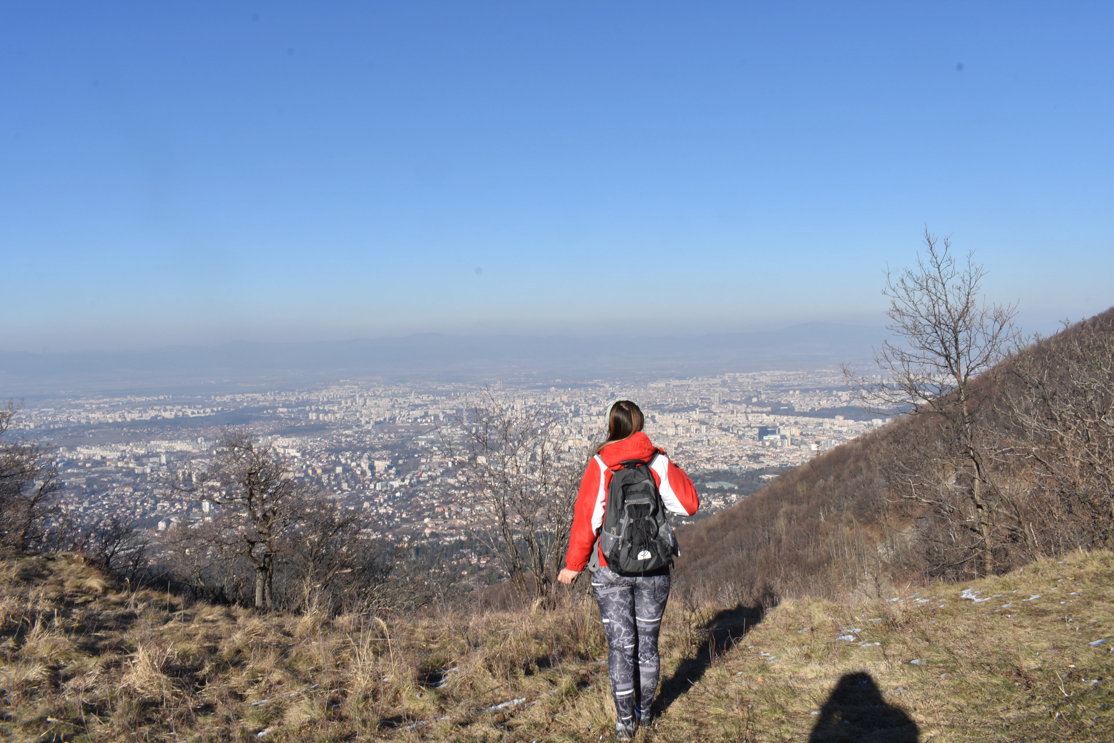 A walker on the open slopes of Vitosha above Sofia, the city spread out on the plain below