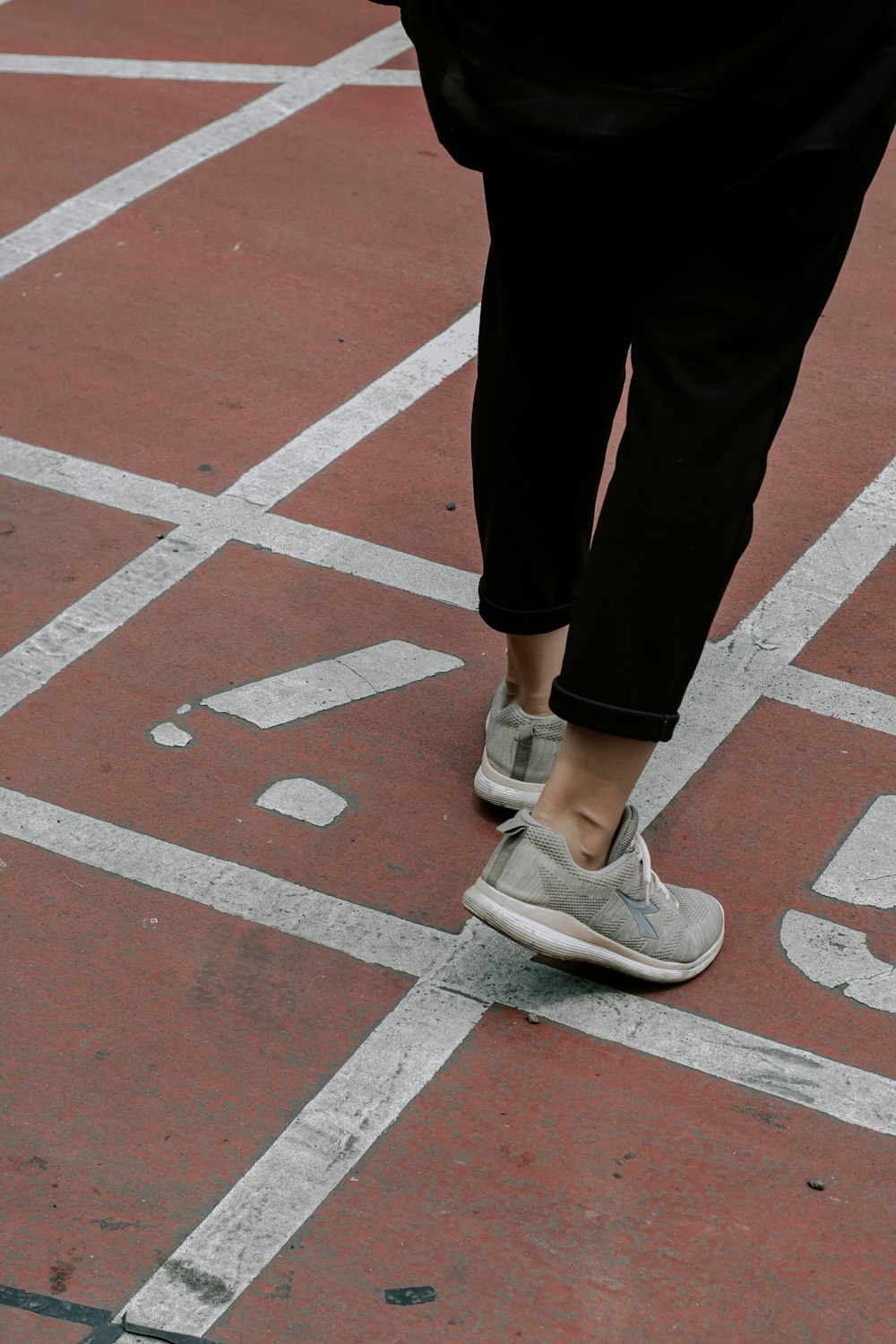 person in black pants and gray and white nike sneakers