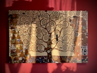 A bold, expressive painting of intertwined tree branches against a muted background.