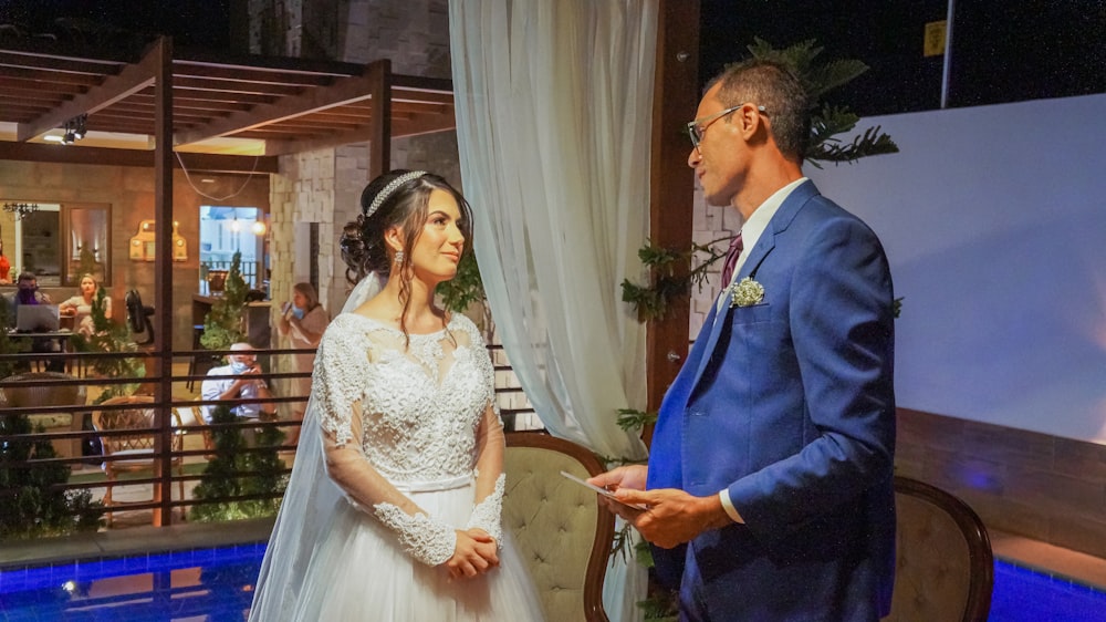 man in blue suit jacket and woman in white wedding dress