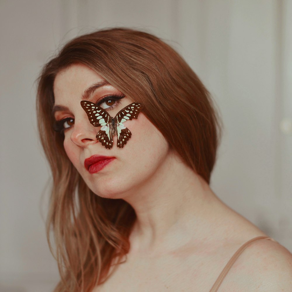 woman with black and silver butterfly face tattoo