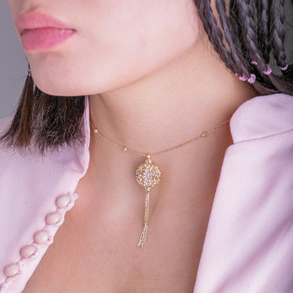 woman wearing gold necklace and white shirt