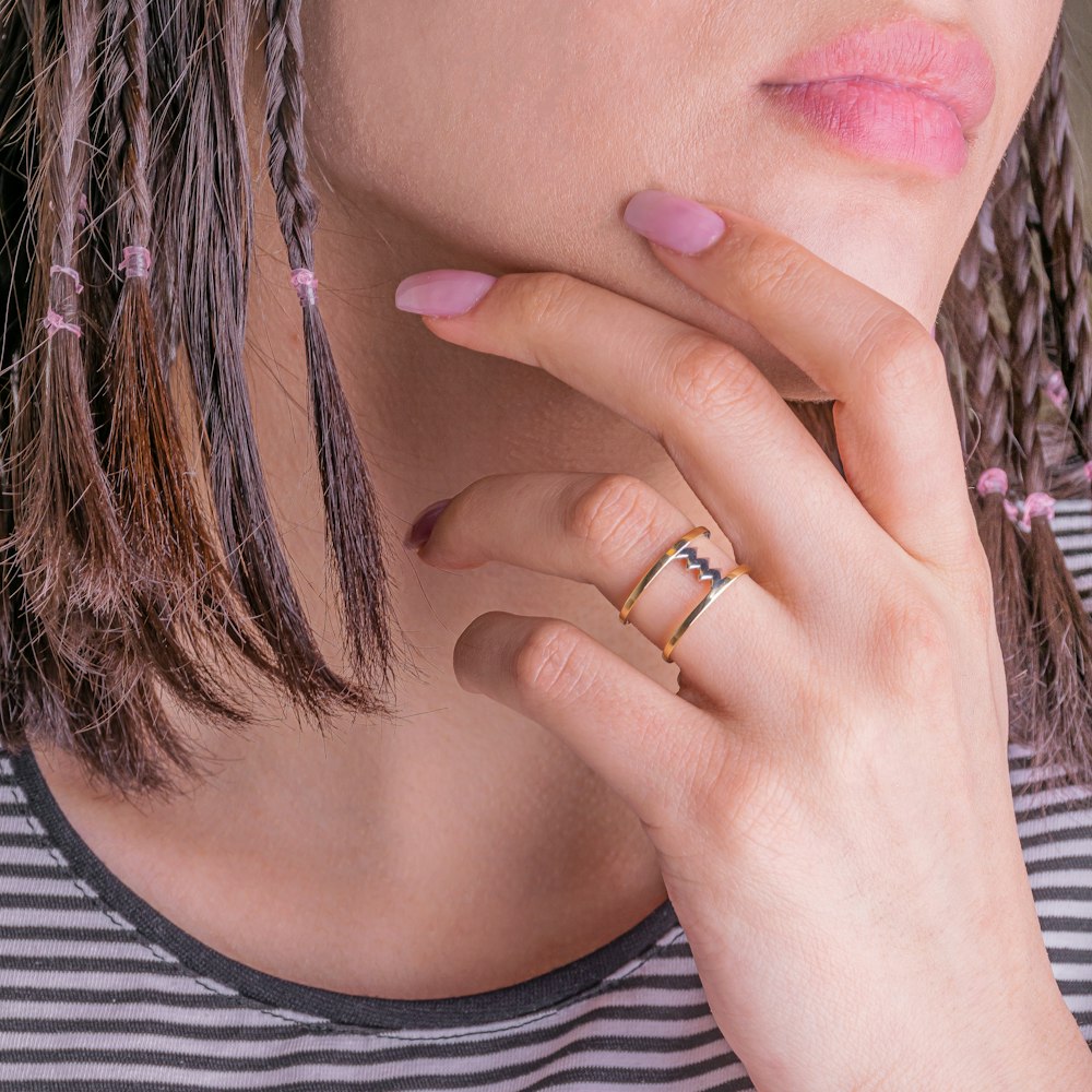 woman in white and black stripe shirt wearing gold ring