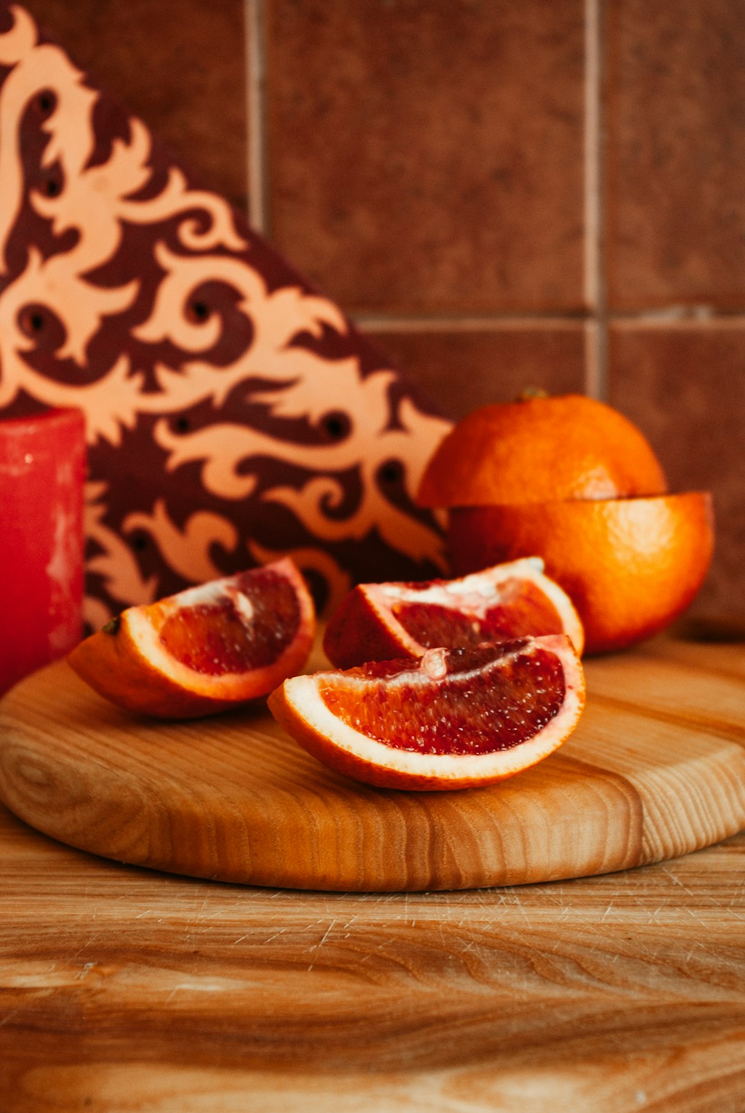 sliced orange fruit on brown wooden chopping board