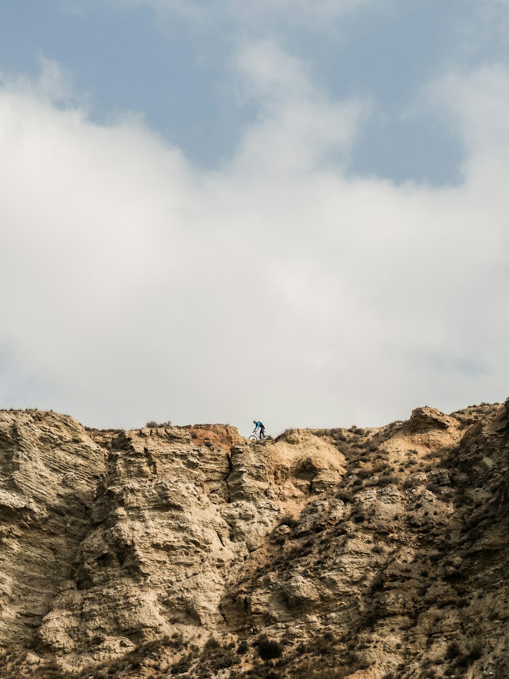 person climbing on brown rock mountain during daytime