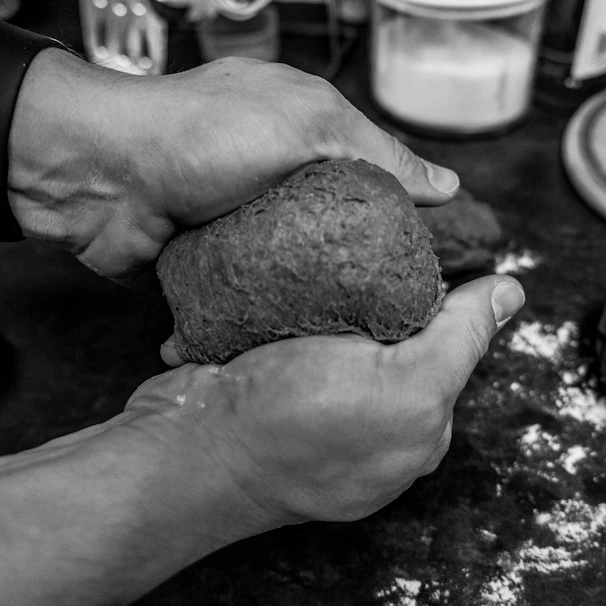 Hands gently shaping dough in a cozy kitchen setting