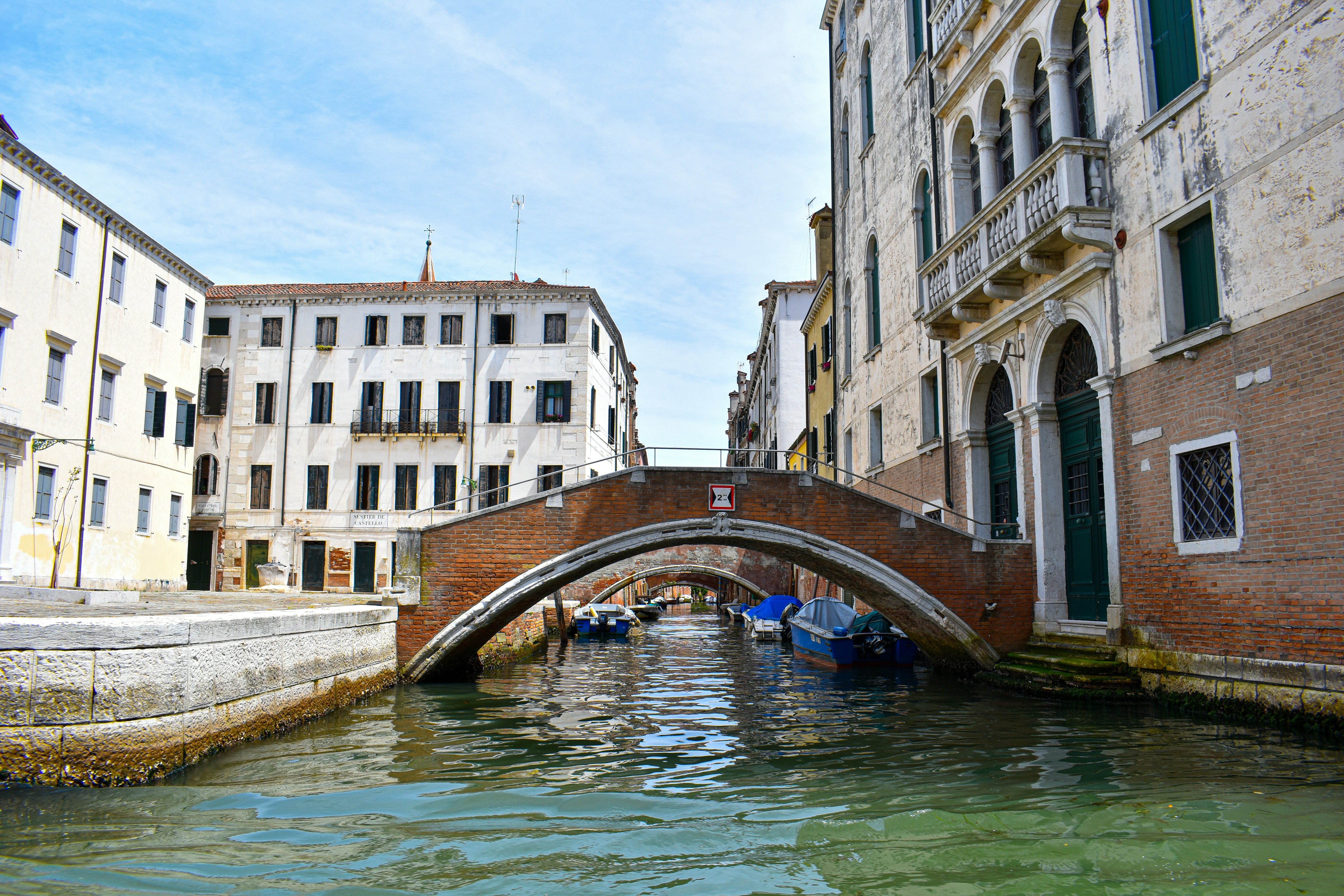 blue boat on river between buildings during daytime