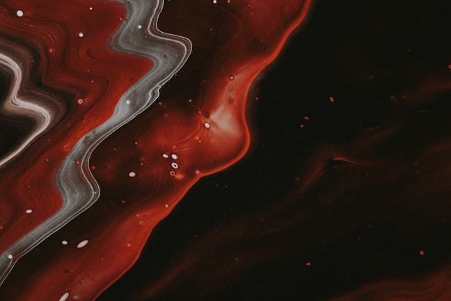 A swirling abstract pattern of smoky gray and deep red with black accents.