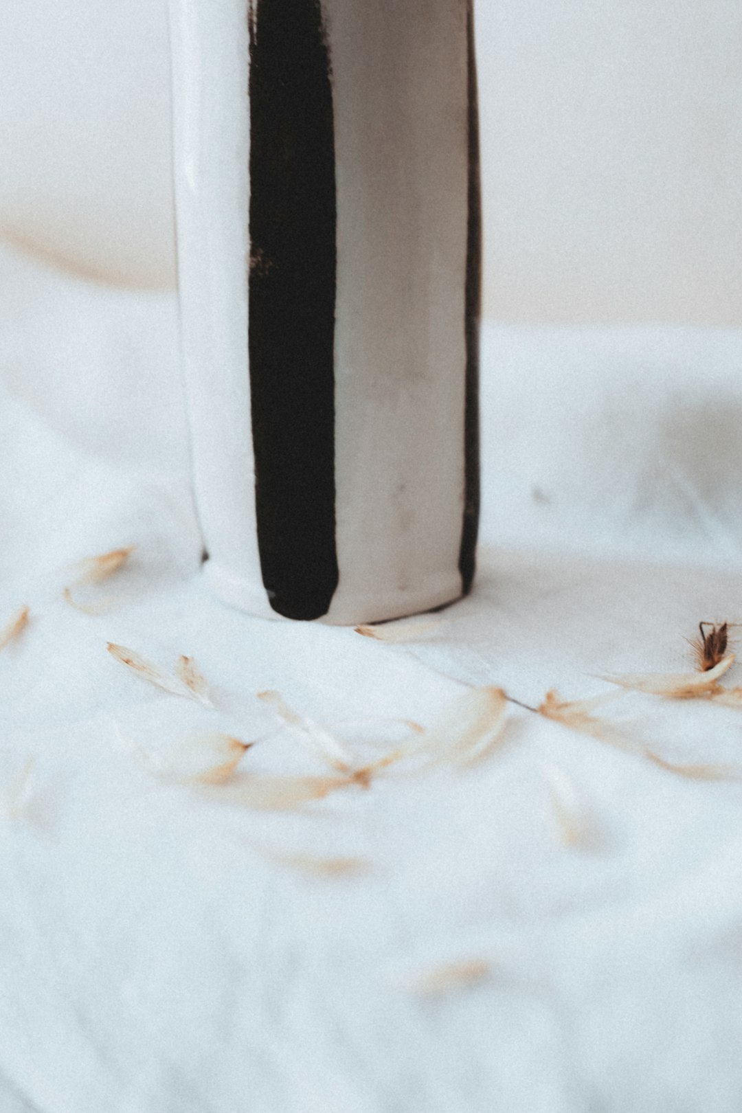 black and silver bottle on white textile